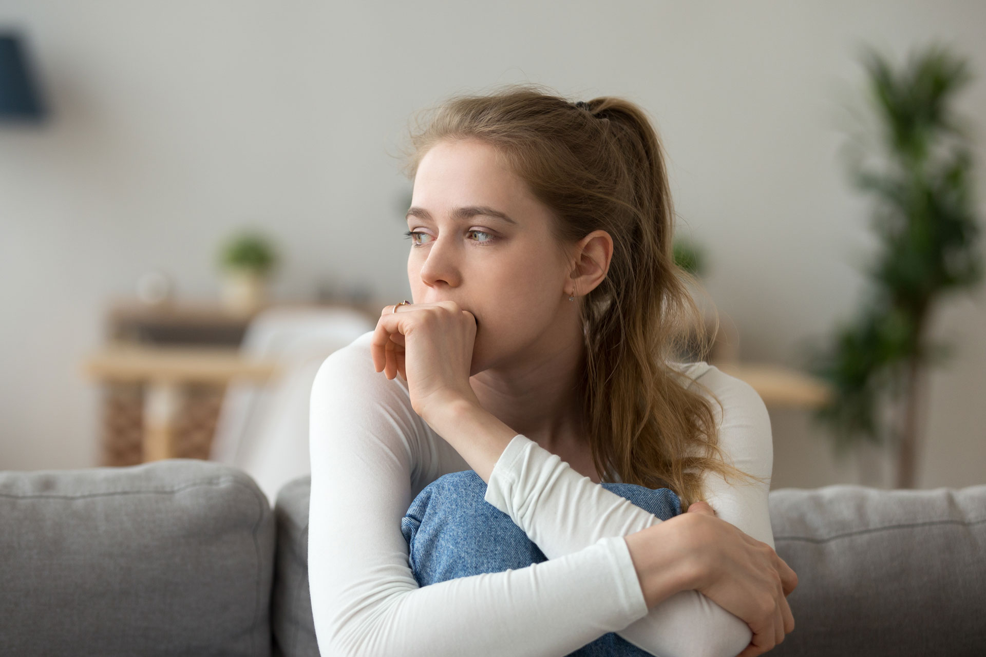 depressed teen girl sitting on couch